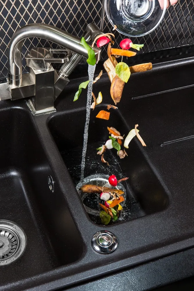 Food scraps being poured into a garbage disposal
