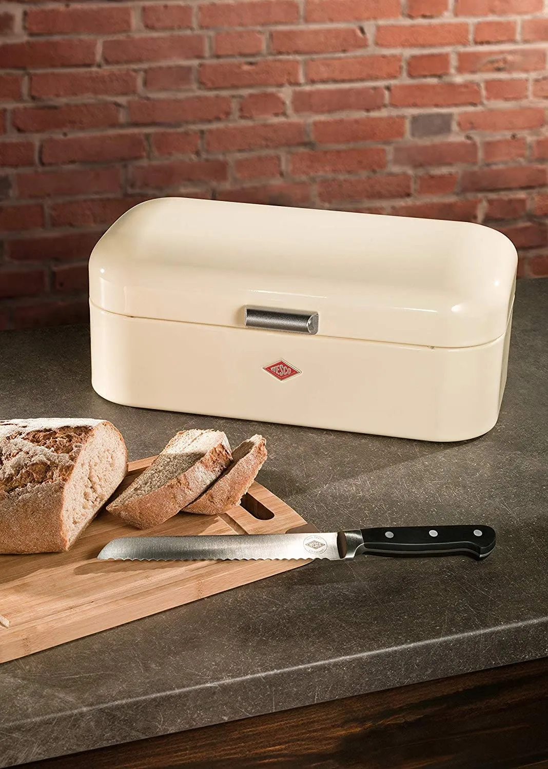 Fresh cut bread next to metal bread box